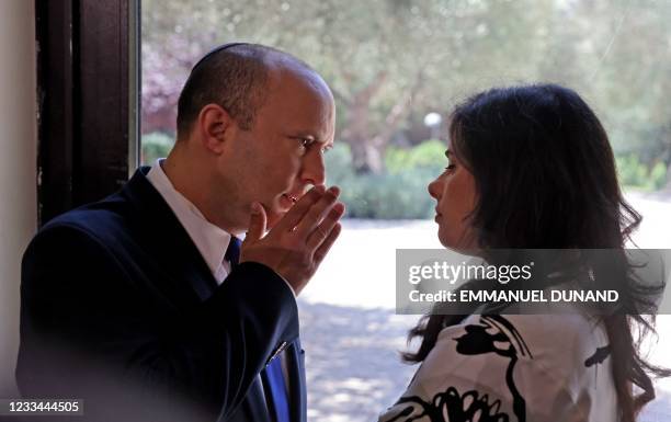 Israeli Prime Minister Naftali Bennett talks to his Minister of Interior Ayelet Shaked at the President's residence during a ceremony for the new...