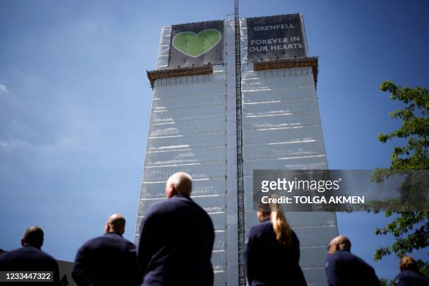 Firefighters pay their respects at a memorial to the victims of the Grenfell Tower fire, in west London on June 14 four years after the fire in the...