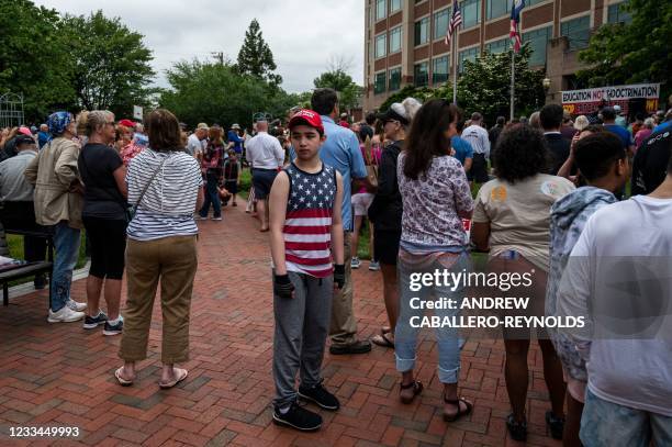 Young boy walks through the crowd during a rally against "critical race theory" being taught in schools at the Loudoun County Government center in...