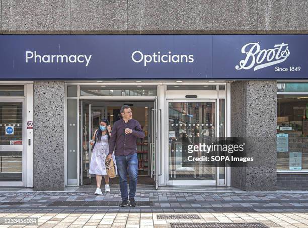 Masked and unmasked customers leave Boots Pharmacy/Opticians on Fountain Street.