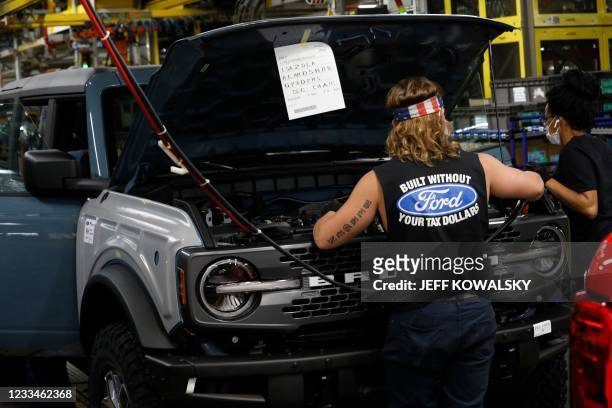 Line workers assemble Ford Motor Company's 2021 Ford Bronco on the line at their Michigan Assembly Plant in Wayne, Michigan on June 14, 2021. -...