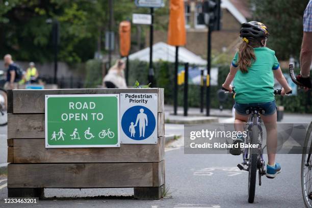 Young cyclist passes through the barriers that form an LTN , an experimental closure by Southwark Council preventing motorists from accessing the...