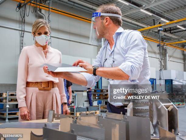 An employee of the Veluw Metal Creations company shows a metal piece to Dutch Queen Maxima in Nieuwkuijk, on June 15, 2021. The visit of Queen Maxima...