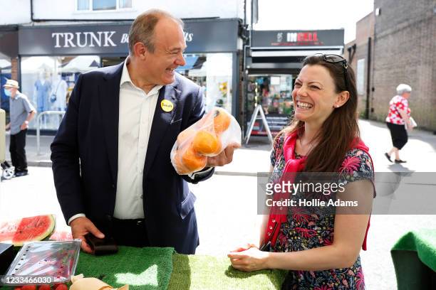 Ed Davey, Leader of the Liberal Democrats gestures with a bag of oranges at Sarah Green, candidate for Chesham and Amersham, while out canvassing on...