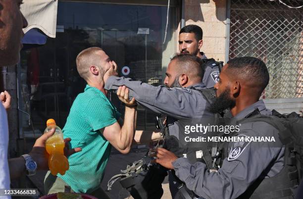Member of the Israeli security forces pushes away a Palestinian man in the Old City of Jerusalem, on June 15 ahead of the March of the Flags which...