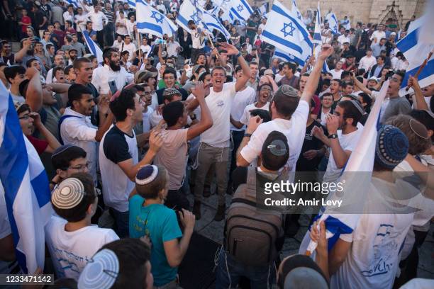 Far right Israelis dance with Israeli flags as they march near Damascus Gate during the flag march on June 15, 2021 in Jerusalem, Israel. Authorities...