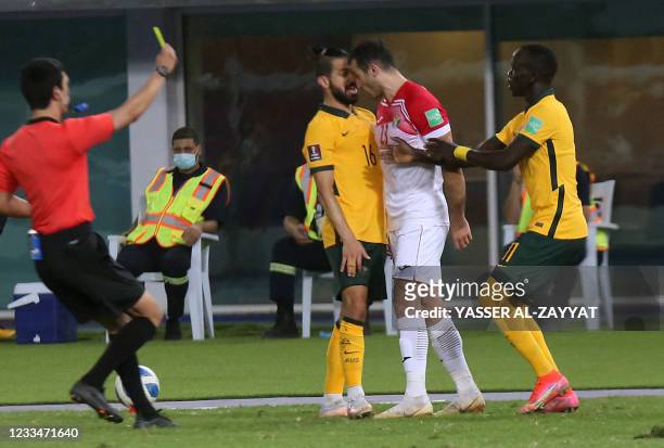 Australia's Aziz Behich argues with Jordan's Ehsan Haddad as the referee gives a yellow card during the 2022 FIFA World Cup qualification group B...