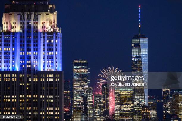 Fireworks explode behind landmark buildings of the Manhattan city skyline including the Empire State building and One World Trade Center ,...