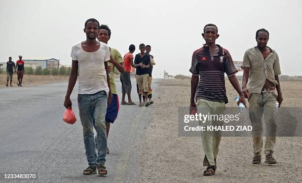 African asylum seekers walk in the coastal area of Ras al-Ara in Yemen's government-held southern province of Lahij on June 15 one day after the...