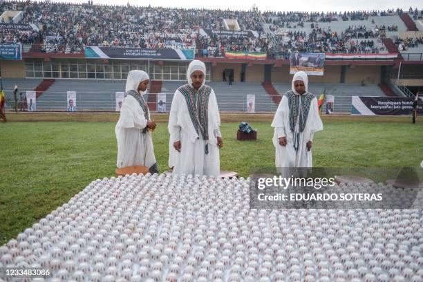 Women in traditional dresses stand next to a traditional coffee ceremony stall in a stadium in Jimma on June 16, 2021 for an electoral campaign rally...