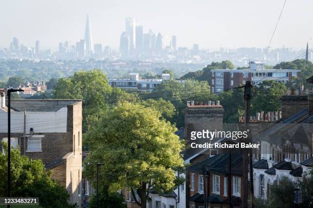 Houses and flats with an elevated viewpoint of the London skyline at Crystal Palace, on 16th June 2021, in London, England.
