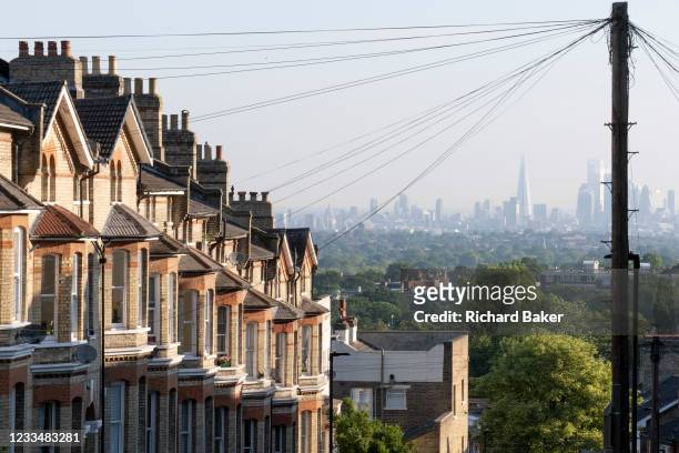 Terraced homes with an elevated viewpoint of the London skyline at Crystal Palace, on 16th June 2021, in London, England.