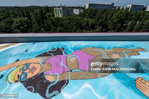 The likeness of a swimmer in a swimming pool is seen on the rooftop of a newly-built residential housing block erected by the Berlin-Brandenburgische...