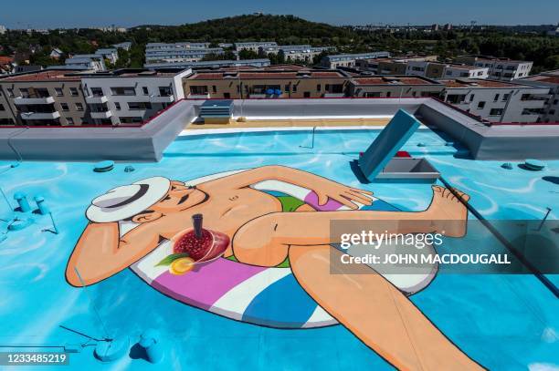 The likeness of a bather in a swimming pool is seen on the rooftop of a newly-built residential housing block erected by the Berlin-Brandenburgische...