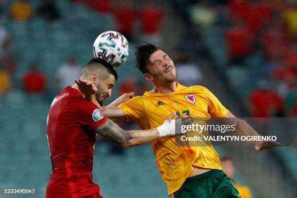 Turkey's midfielder Okay Yokuslu vies with Wales' midfielder Kieffer Moore during the UEFA EURO 2020 Group A football match between Turkey and Wales...