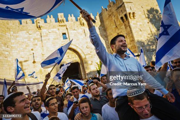Bezalel Yoel Smotrich is hoisted up by far right Israelis as they danced and waved the national flag rally outside the Old Citys Damascus gate for...