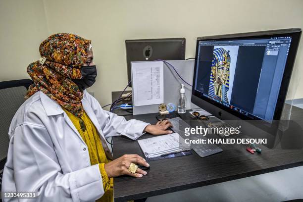 Graphic designer retouches an image of the funerary mask of the Pharaoh Tutankhamun while producing a computer-assisted design at the Egyptian...