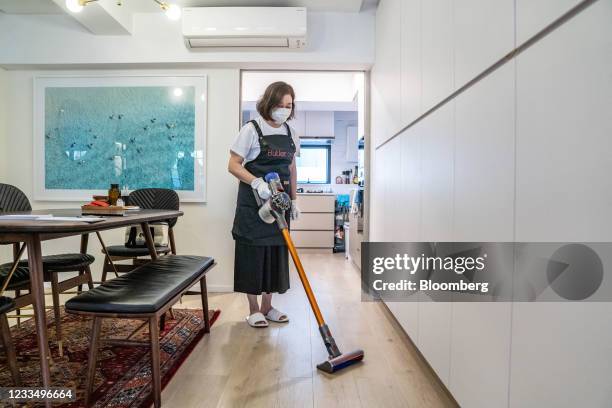 An employee of Butler, a home concierge company that offers personalized services, vacuums the floor at a client's home in Hong Kong, China, on...