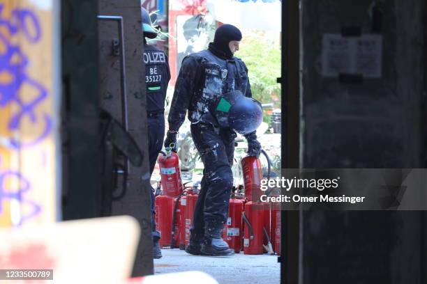 Police officer carries fire extinguisher found at the Rigaer Strasse 94 leftist squat on the day a fire inspector is to carry out an inspection at...