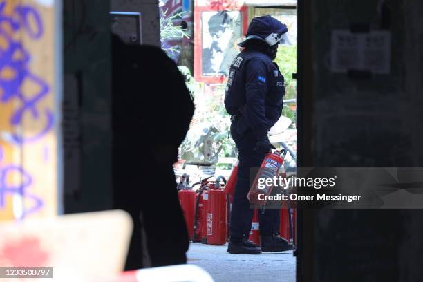 Police officer carries fire extinguisher found at the Rigaer Strasse 94 leftist squat on the day a fire inspector is to carry out an inspection at...