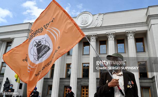 Chernobyl nuclear catastrophe 'liquidator' holds a flag during a rally organized by "Union of Chernobyl of Ukraine" outside the Ukrainian Parliament...