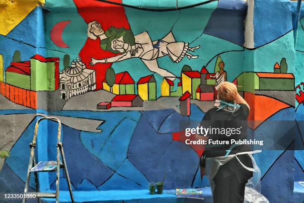 An artist works on a mural at the Migdal Jewish Centre on Mala Arnautska Street inspired by Marc Chagall's Over the Town, Odesa, southern Ukraine.