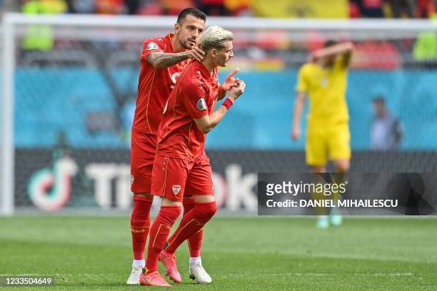 North Macedonia's defender Ezgjan Alioski celebrates with North Macedonia's forward Aleksandar Trajkovski after scoring his team's first goal during...