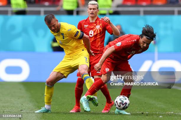 Ukraine's forward Andriy Yarmolenko fights for the ball with North Macedonia's defender Ezgjan Alioski and North Macedonia's midfielder Eljif Elmas...