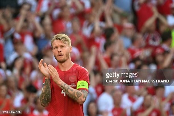 Denmark's defender Simon Kjaer claps after the ball was kicked out of play in honour of Denmark's midfielder Christian Eriksen during the UEFA EURO...