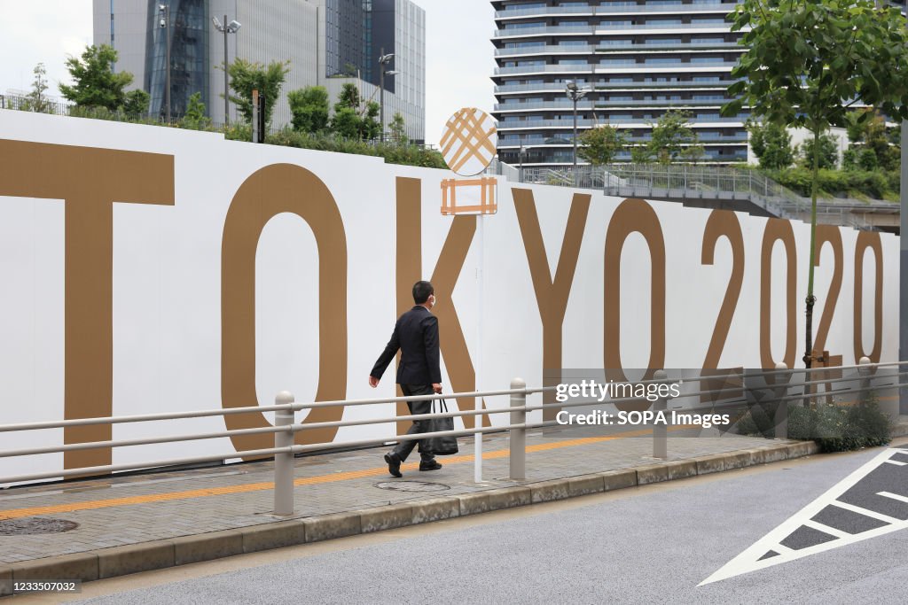 Businessman with a suitcase walks by Tokyo 2020 Olympic...