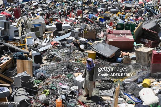 Man selects valuable items at a recycling workshop near the Bagram Air Base, in Bagram on June 17, 2021.