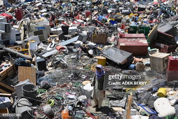 Man selects valuable items at a recycling workshop near the Bagram Air Base, in Bagram on June 17, 2021.