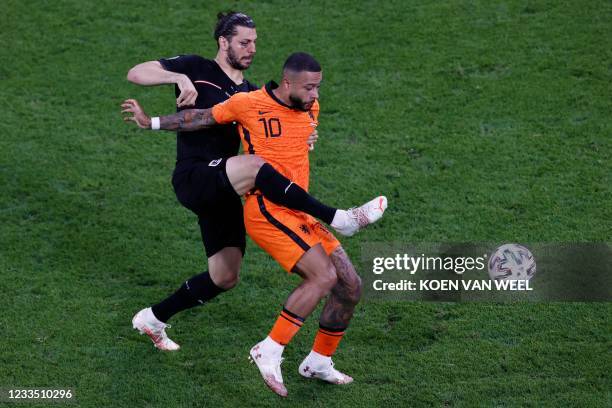 Austria's defender Aleksandar Dragovic challenges Netherlands' forward Memphis Depay during the UEFA EURO 2020 Group C football match between the...