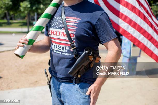 Kenny Wolfam open carries a pistol and wears a "Trump 2020" t-shirt while counter-protesting a "Moms Demand Action" protest in response to a new...