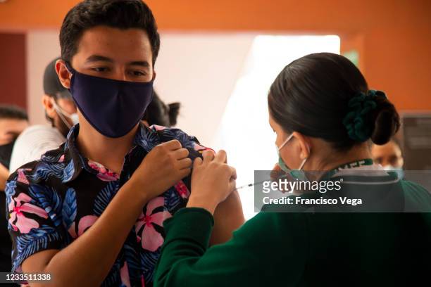 Health worker administers a dose of the COVID-19 vaccine at the mass vaccination center of the Universidad de Baja California on June 17, 2021 in...