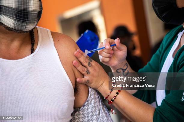 Health worker administers a dose of the COVID-19 vaccine to a citizen at the mass vaccination center of the Universidad de Baja California on June...