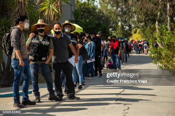 Citizens line up outside a vaccination center to receive the Johnson & Johnson vaccine against Covid-19 at Universidad de Baja California on June 17,...