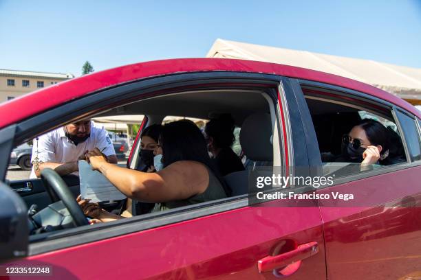 Citizens in a car attend the drive-in vaccination center to receive the U.S. Donated Johnson & Johnson vaccine against Covid-19 at Universidad de...