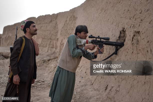 In this photograph taken on March 28 members of the anti-Taliban "Sangorians" militia take position during an ongoing fight with Taliban insurgents...