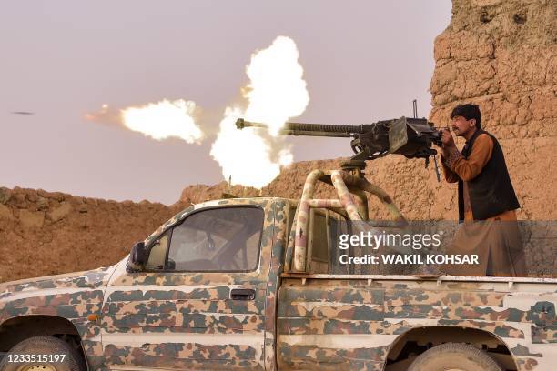 In this photograph taken on March 28 a member of the anti-Taliban "Sangorians" militia fires a heavy machine gun during an ongoing fight with Taliban...
