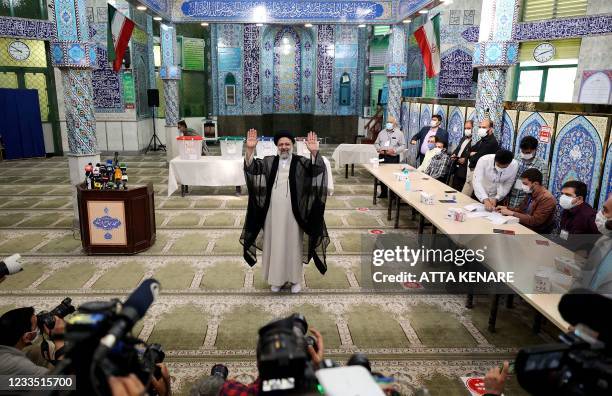 Iranian ultraconservative cleric and presidential candidate Ebrahim Raisi waves after casting his ballot for presidential election, in Tehran, on...