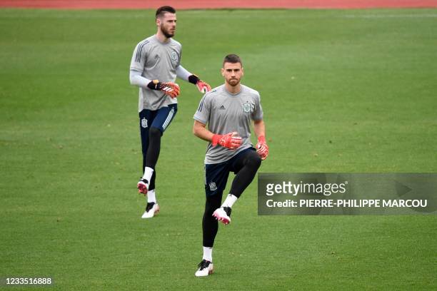 Spain's goalkeeper David De Gea and Spain's goalkeeper Unai Simon warm up during their MD-1 training session at Las Rozas near Madrid on June 18,...