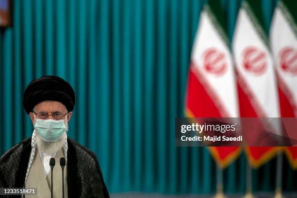 Iran's Supreme Leader Ayatollah Ali Khamenei wears a face mask due to the Covid-19 pandemic, as he stands after casting his ballot, on June 18 on the...