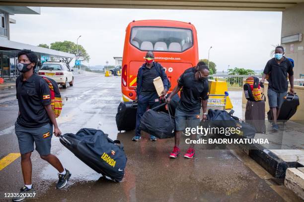 The Uganda National boxing team's Catherine Nanziri and other arrive for check-in with their baggage at Entebbe international airport in Wakiso,...