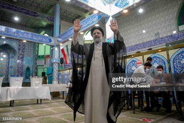 Ebrahim Raisi, a candidate in Iran's presidential elections waves to the media after casting his vote at a polling station on June 18 on the day of...