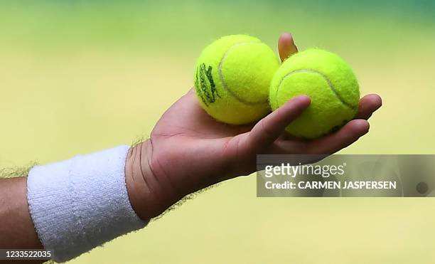 Marcos Giron from the USA holds tennis balls in his hands as he plays against Canada's Felix Auger-Aliassime during their men's quarter-final singles...