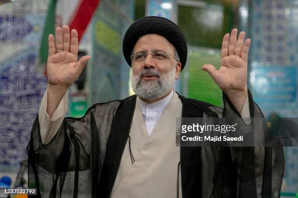 Ebrahim Raisi, a candidate in Iran's presidential elections waves to the media after casting his vote at a polling station on June 18 on the day of...