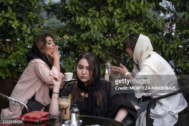 Iranian women sit at a cafe in the Ekbatan neighbourhood in western Tehran on Presidential elections day, on June 18, 2021. - Iranians voted in a...