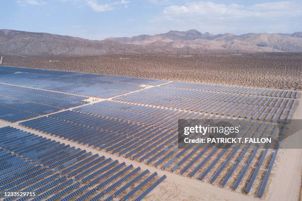 An aerial image shows solar panels part of an electricity generation plant on June 18, 2021 in Kern County near Mojave, California. - The California...