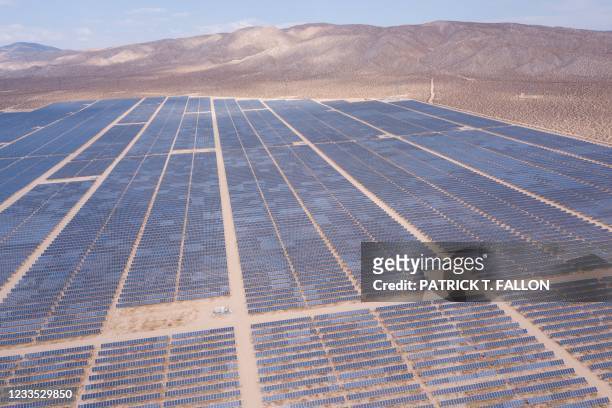 An aerial image shows solar panels part of an electricity generation plant on June 18, 2021 in Kern County near Mojave, California. - The California...